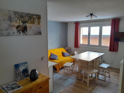 a living room with a table and a dining room at Studio du lac bleu in Morillon