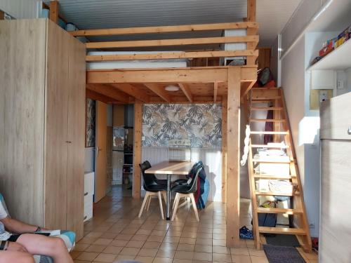 Cette chambre comprend une mezzanine, une table et des chaises. dans l'établissement Studio 2 à 4 personnes avec garage privé, à Le Mont-Dore