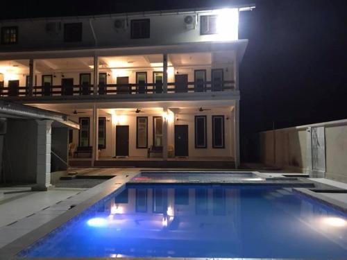 ein großer Pool vor einem Haus in der Nacht in der Unterkunft Fikri Wetland Guesthouse & Resort 