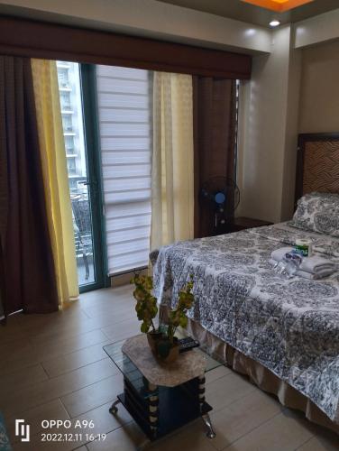 een slaapkamer met een bed en een tafel met een plant bij CondoTel Pasay Newport City in Manilla