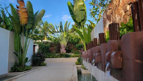 a walkway in a building with trees and plants at WAKA VILLA Private Pool Resort & Spa - Adults Only in Siem Reap