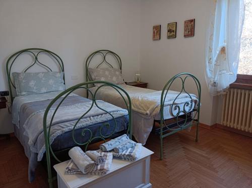 1 dormitorio con 2 camas y una mesa con zapatos en Al Picchio Verde A.P.S., en Cunardo
