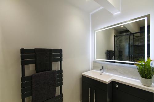 y baño con lavabo y espejo. en Harbour Heights, Luxury Coastal Apartment in The English Riviera, close to the Shops, Bars, Restaurants, Marina and Beaches, en Torquay