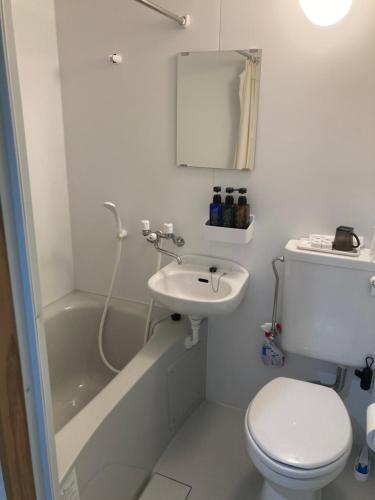 een witte badkamer met een toilet en een wastafel bij エスポアールあま 