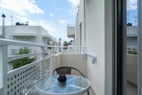 a glass table on a balcony with a view at Esperos Studios and Apartments, #6 in Stalida