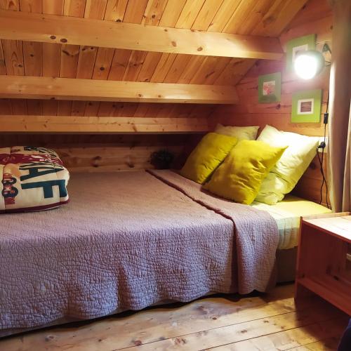 une chambre dans une cabane en rondins avec un lit dans l'établissement CHALET Meleze Etapeboisee, à Fumay
