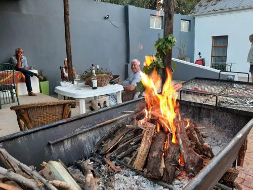 a man sitting at a grill with a fire at @19 Queenstreet in Calitzdorp