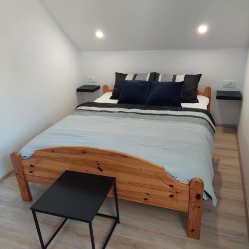 Un dormitorio con una gran cama de madera y una mesa. en Apartmaji Biseri, en Kranjska Gora
