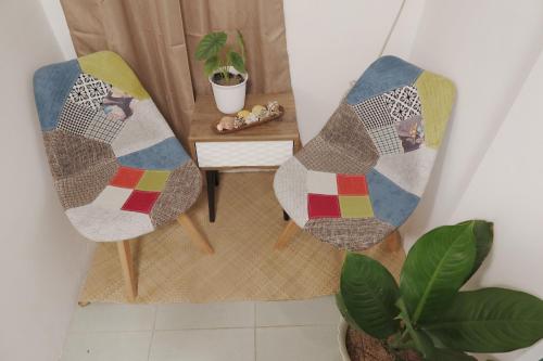 a room with two chairs and a table with a quilt at AJ Coffee & Bed in Coron