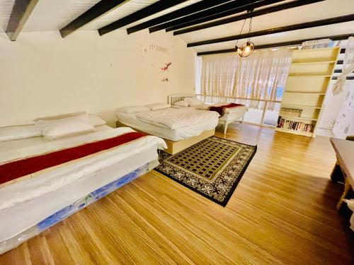 Habitación con 2 camas y sofá. en Yilan Night Market Whole House, en Yilan City