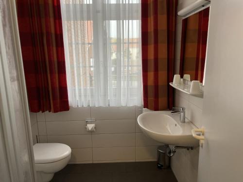 a bathroom with a toilet and a sink at Hotel Alte Post Ostbevern in Ostbevern