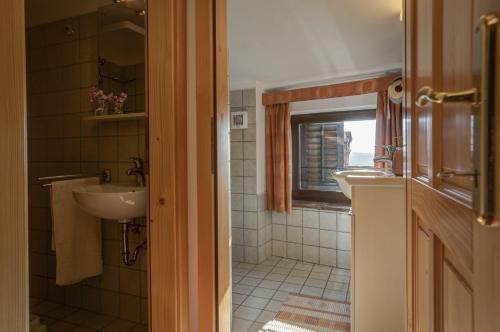 a bathroom with two sinks and a window at Apartmaji in sobe Marija Jera Štanjel in Štanjel