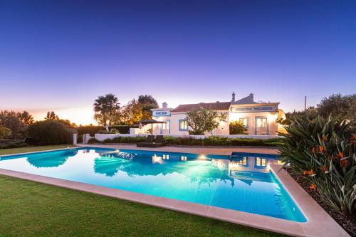 a swimming pool in the yard of a house at Casa Flor de Sal in Moncarapacho