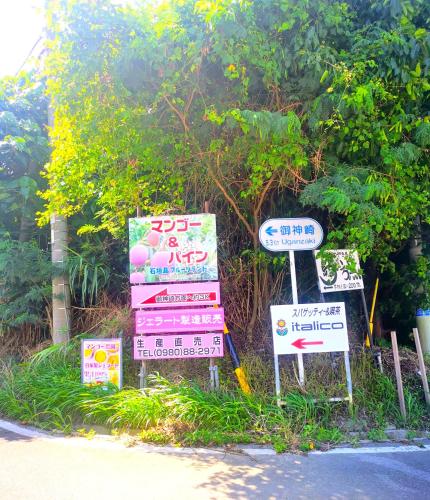 a group of signs on the side of a road at ハレマヤ 一軒家 Haremaya in Ishigaki Island