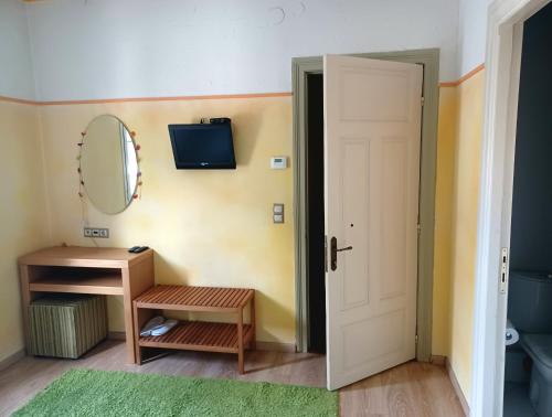 uma casa de banho com um lavatório, um espelho e uma porta em Room "honeybee" in a neoclassical house em Kastoria
