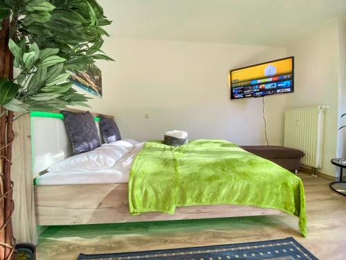 Un dormitorio con una cama con una manta verde. en Wohlfühl-Apartment mit kostenfreier Tiefgarage, WiFi und Kaffee, en Leipzig