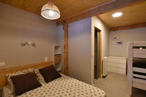 sypialnia z łóżkiem i żyrandolem w obiekcie Chalet de montagne w mieście Formiguères