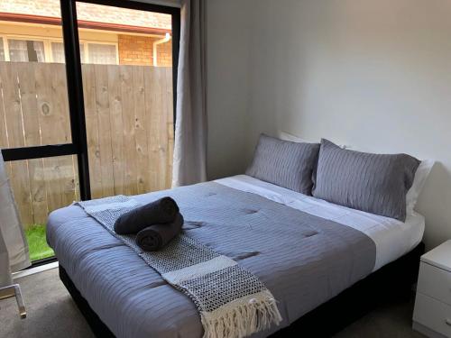 a bedroom with a bed with a towel and a window at Cozy Brand New Townhouse 35 in Auckland