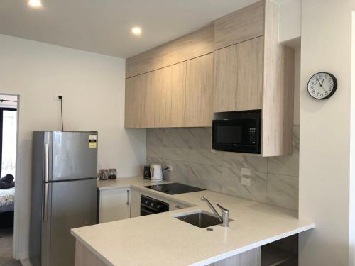 a kitchen with a sink and a refrigerator at Cozy Brand New Townhouse 35 in Auckland