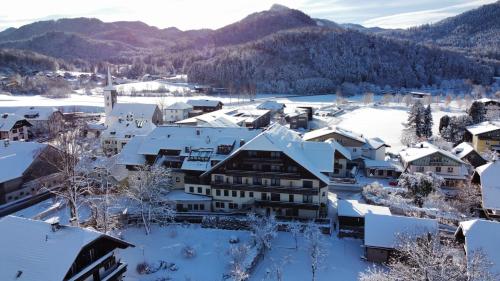 a town covered in snow with mountains in the background at Hotel Jakob in Fuschl am See