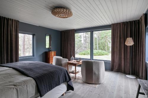 Schlafzimmer mit einem Bett, einem Schreibtisch und Fenstern in der Unterkunft Luxury family home near the water for eight people in Stockholm