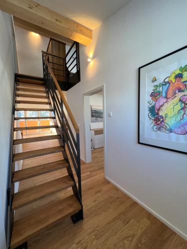 eine Treppe in einem Haus mit einem Gemälde an der Wand in der Unterkunft Haus Wiesenquelle, Deluxe-Apartment 'Feld & Berg' in Feldberg