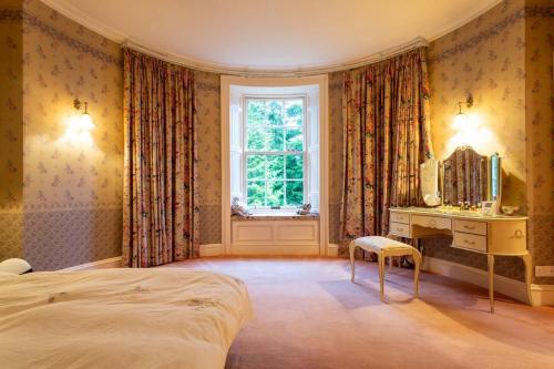 a bedroom with a bed and a vanity and a mirror at 18th Century Manor with Sauna 