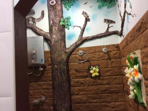 een badkamer met een boom en vogels op de muur bij Himawari Restaurant & Cottage in Ban Nong Hin