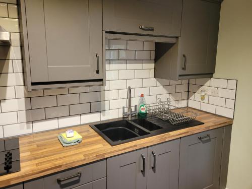 a kitchen with a sink and a counter top at Stunning 2 bedroom cottage on the River Wensum in Earlham