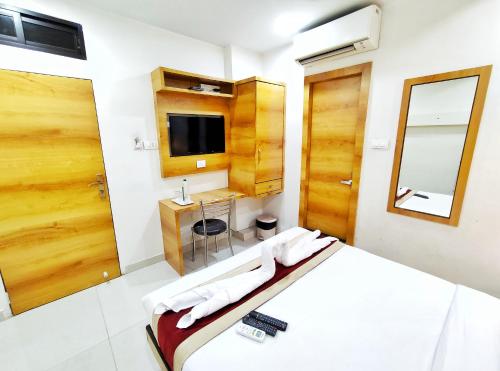 1 dormitorio con cama, lavabo y espejo en Gateway Suites, en Bombay
