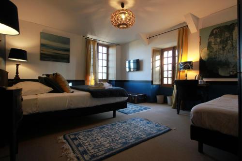 a bedroom with two beds and a chandelier at La Haute Flourie - bed and breakfast -chambres d'hôtes in Saint Malo