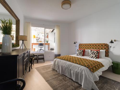 ein Schlafzimmer mit einem Bett, einer Kommode und einem Fenster in der Unterkunft Cosmopolitan Design By CanariasGetaway in Las Palmas de Gran Canaria