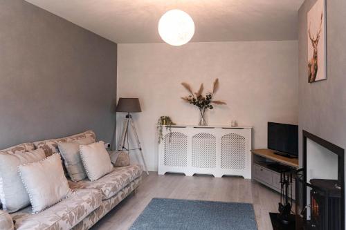 a living room with a couch and a tv at Glen Burren House in Newcastle