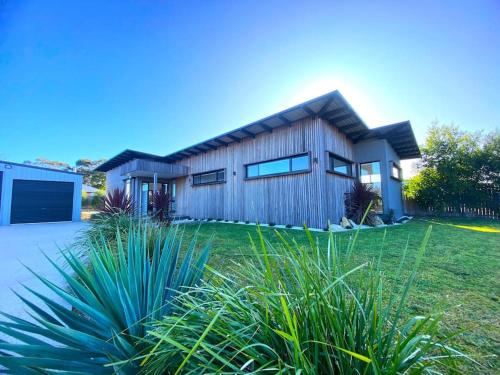 a house with a wooden facade with a yard at Scandi at Stieglitz Sleeps 6 Modern & Stylish in St Helens