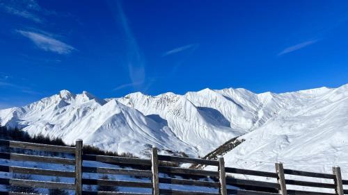 a fence in front of a snow covered mountain at la foux d'allos au pied des pistes in La Foux