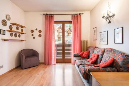 a living room with a couch and a chair at Delizioso appartamento trilocale a Moena in Moena