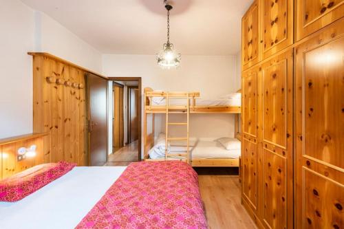 a bedroom with a bed and a bunk bed at Delizioso appartamento trilocale a Moena in Moena
