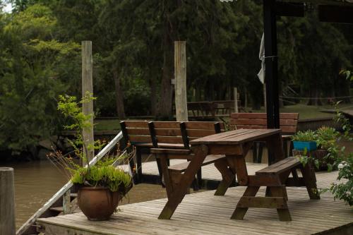 a wooden picnic table and bench on a wooden deck at Cabañas ICh in Tigre