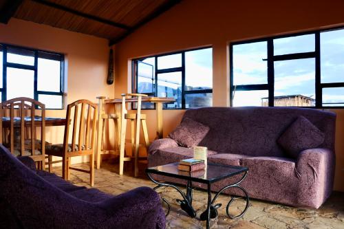 a living room with two couches and a table at The Red House in Amboseli
