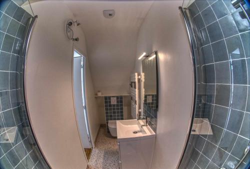 La salle de bains est pourvue d'un miroir et d'un lavabo. dans l'établissement Appartement neuf proche de la mer, à Beaussais sur Mer