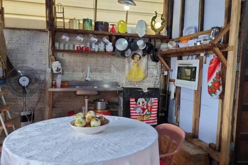 a kitchen with a table with a bowl of fruit on it at VELHO OESTE Carruagens, Casa Inteira !! in Matinhos