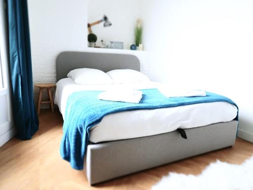 - un lit avec une couverture bleue dans une chambre dans l'établissement L'ALBERT 1er - Ancien Palace - Centre ville - Terrasse, à Vichy