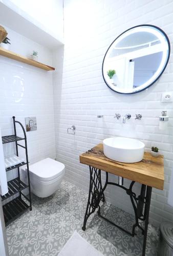une salle de bain avec un lavabo et un miroir et des toilettes dans l'établissement L'ALBERT 1er - Ancien Palace - Centre ville - Terrasse, à Vichy
