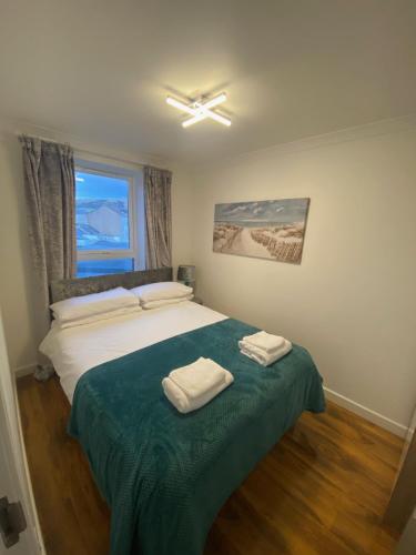 a bedroom with a bed with two towels on it at cosy 1 bed flat Largs in Largs