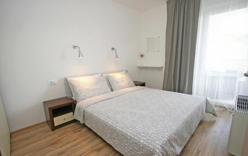 a white bedroom with a bed and a window at Jurman Apartment in Barbariga