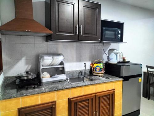 a kitchen with a sink and a microwave at Beach Home Lanta in Ko Lanta