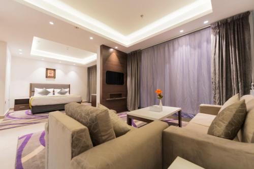 a hotel room with a couch and a bed at Riyadha Home Apartment in Riyadh