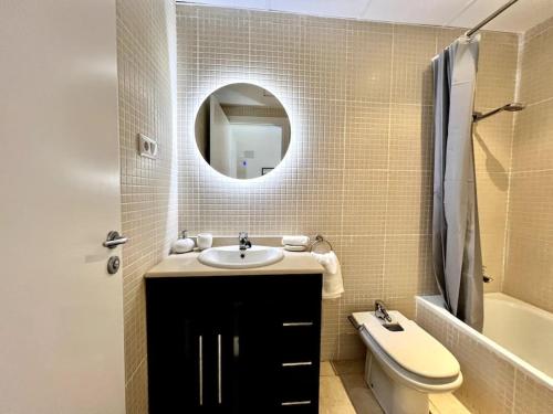 a bathroom with a sink and a toilet and a mirror at Acogedor apartamento entero in Terrassa