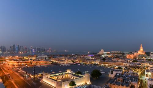 a view of a city at night at Alwadi Hotel Doha - MGallery Collection in Doha