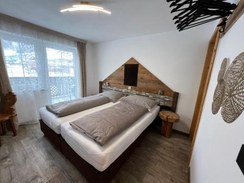 a bedroom with a bed with a wooden headboard at Haus Eder Steiner in Saalbach Hinterglemm